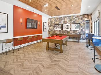 a game room with a pool table and a bar